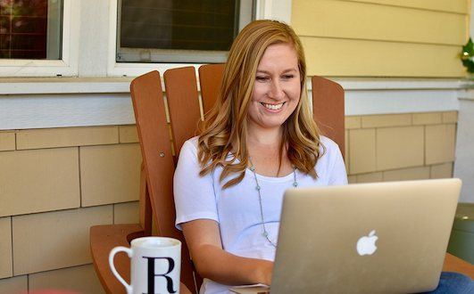 Rachael Roehmholdt Sitting in a Chair Looking at Laptop